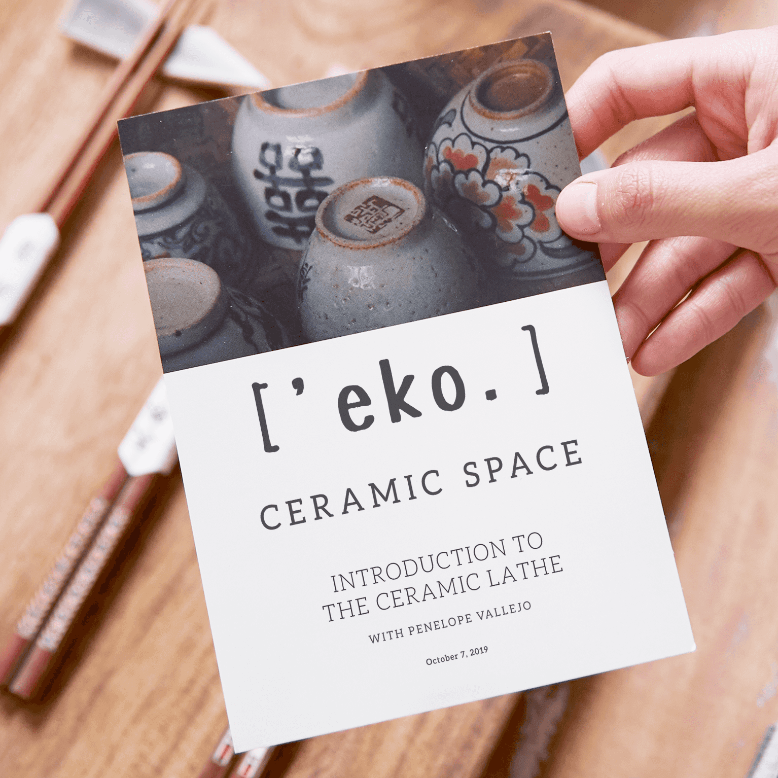 Hand holding a printed flyer for a ceramics business called 'eko. featuring photos of painted ceramic bowls.
